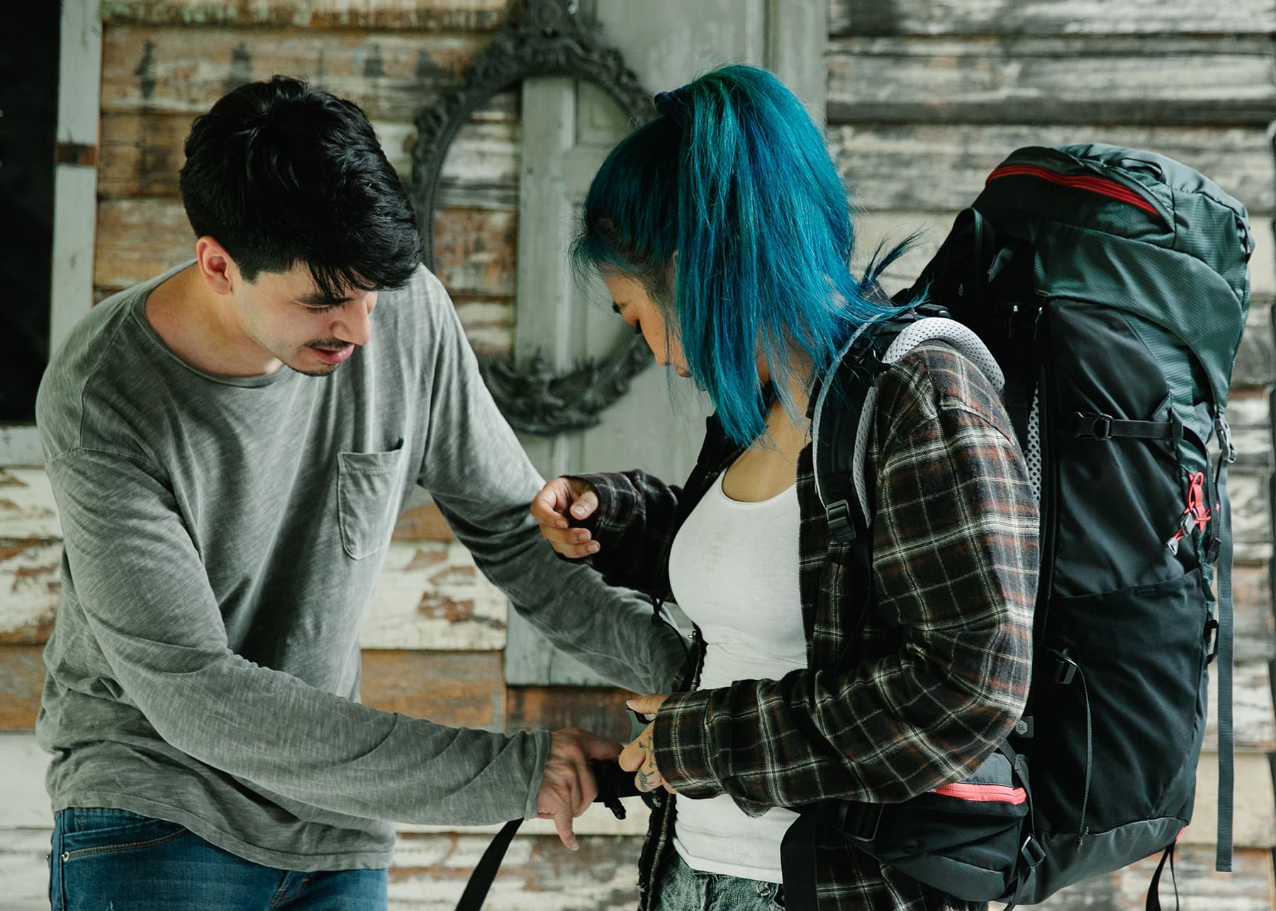 Two travelers with a backpack packing for a trip, surrounded by travel gear and essentials, preparing for an adventure